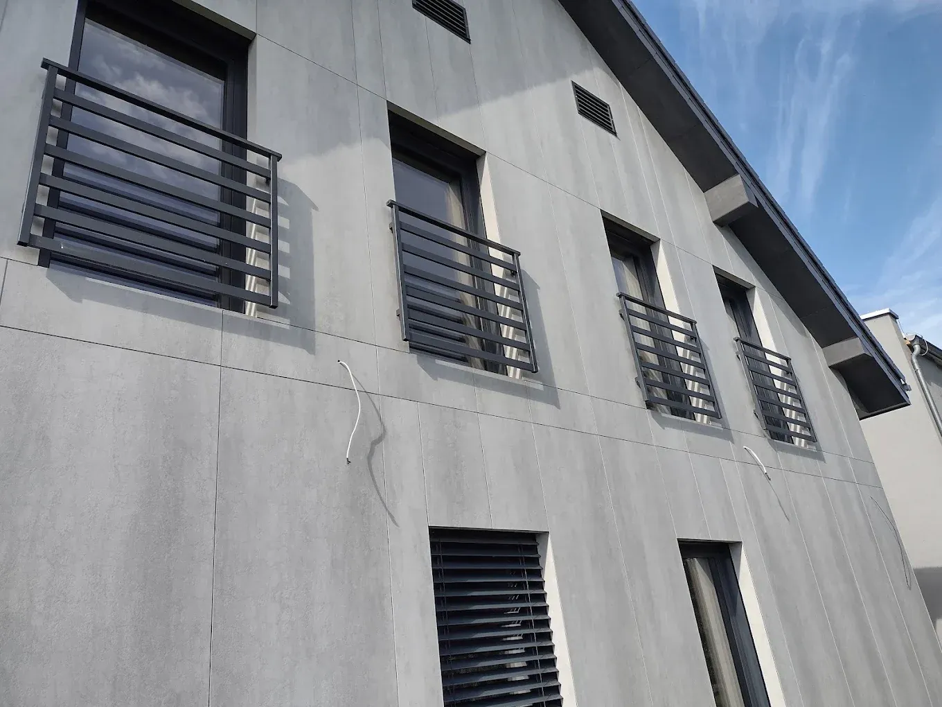 Balustrady balkonowe na elewacji budynku wielorodzinnego